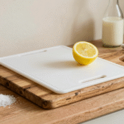 Planche en bois et planche en plastique côte à côte avec citron, gros sel et vinaigre blanc