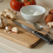 Plan de travail avec ail, gingembre frais, tomates, œufs durs, couteau et cuillère à café