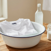 Tee-shirts en coton trempant dans une bassine émaillée, avec vinaigre blanc et bicarbonate posés à côté