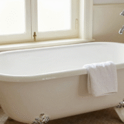 Baignoire ancienne en fonte émaillée d'un blanc impeccable dans une salle de bains à l'ancienne