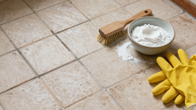 Joints de carrelage au sol à moitié blanchis, avec brosse et pâte de bicarbonate