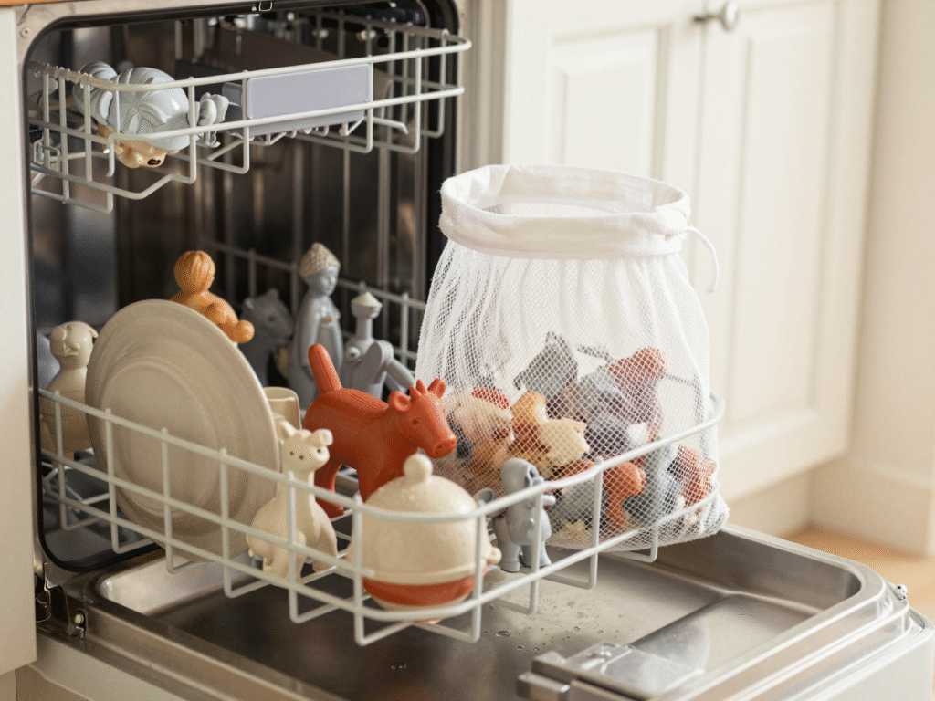 Panier supérieur d'un lave-vaisselle chargé de jouets en plastique rigide et d'un filet à linge