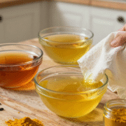 Trois bains de teinture naturelle au thé, aux pelures d'oignon et au curcuma avec du tissu de coton blanc sur une table en bois